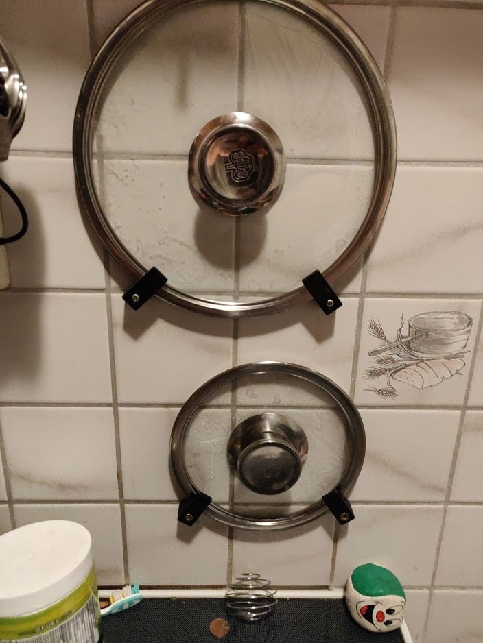 Wandgemonteerde houder voor deksels