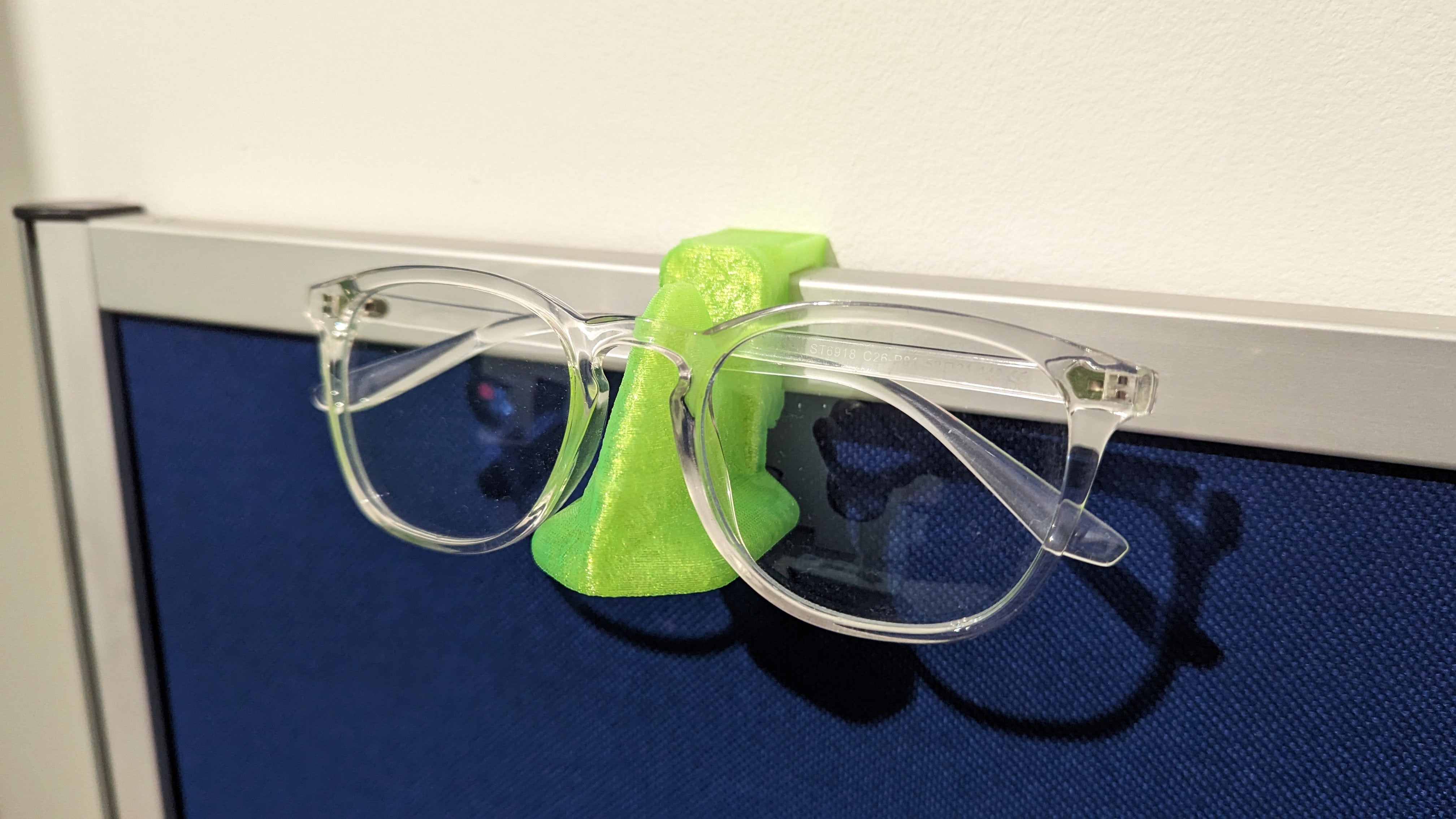 Neusvormige brillenhouder voor bureauafscheiding